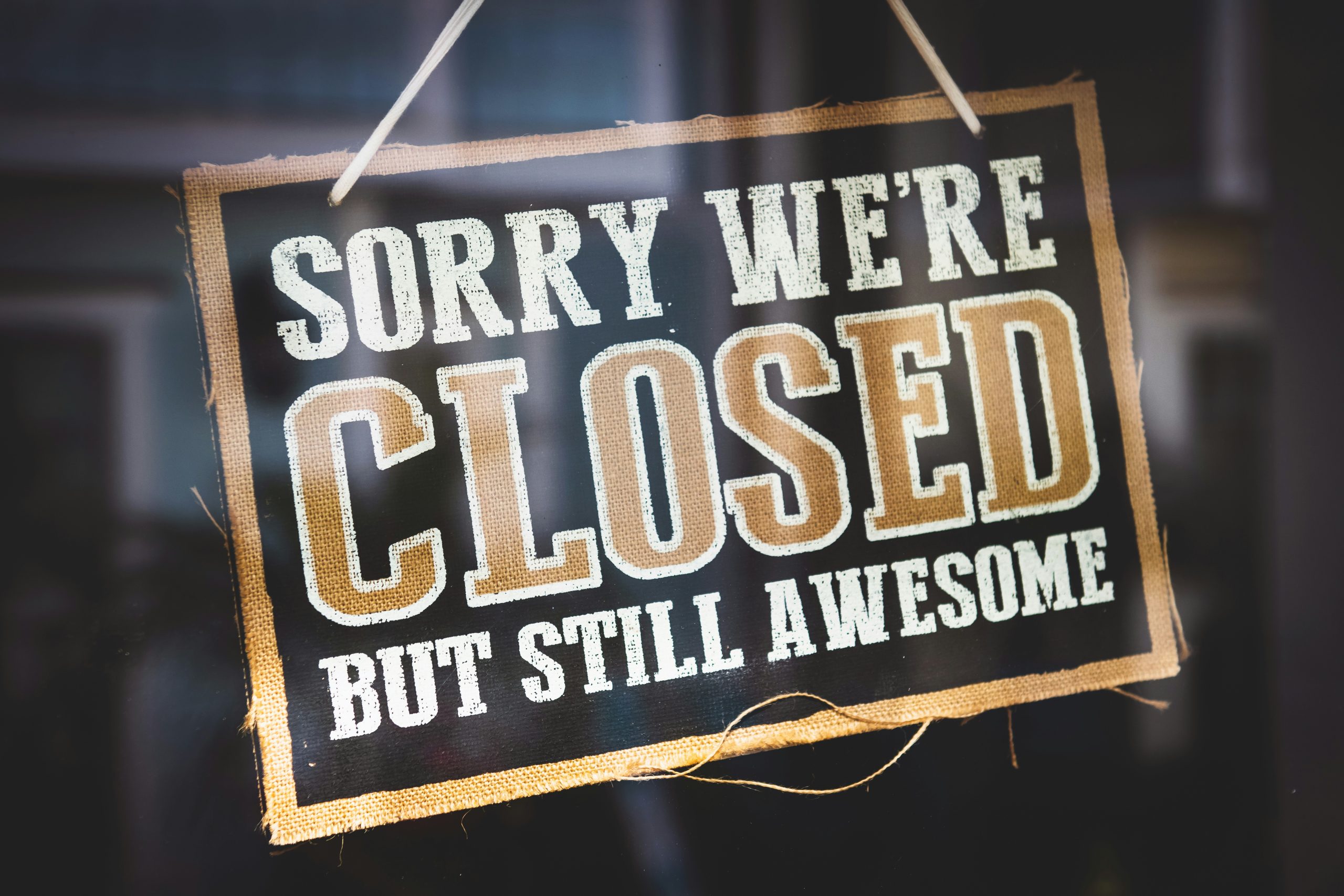 Hanging sign that reads "Sorry we're closed but still awesome"